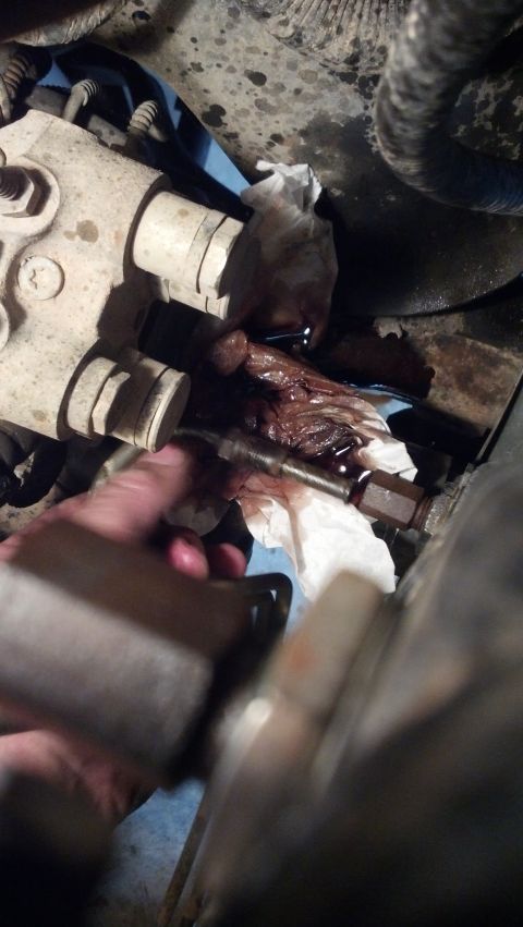 1993 Ford Bronco - Cleaning a greasy engine part with a rag.