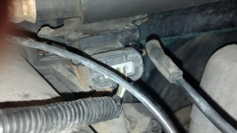 1993 Ford Bronco - A close-up view of an electrical connector and wiring harness within a vehicle's engine compartment.