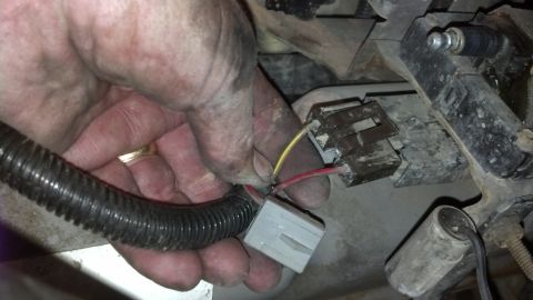 1993 Ford Bronco - A hand is shown connecting electrical wiring harnesses, likely during a vehicle repair or modification.