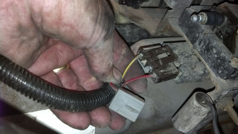 Hand connecting electrical connectors with red and yellow wires