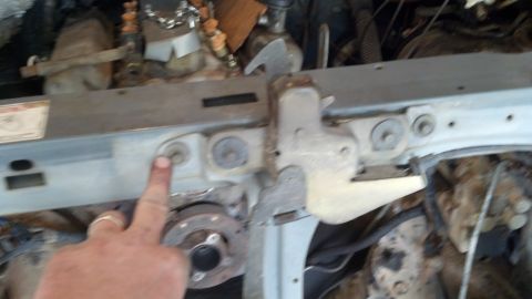 1993 Ford Bronco - Engine bay components are visible, with a hand pointing to a bolt on the radiator support.