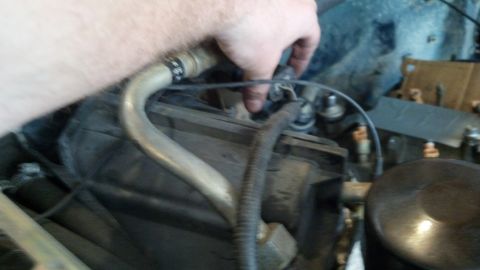 1993 Ford Bronco - A hand is shown manipulating a hose connection within the engine compartment of a vehicle.