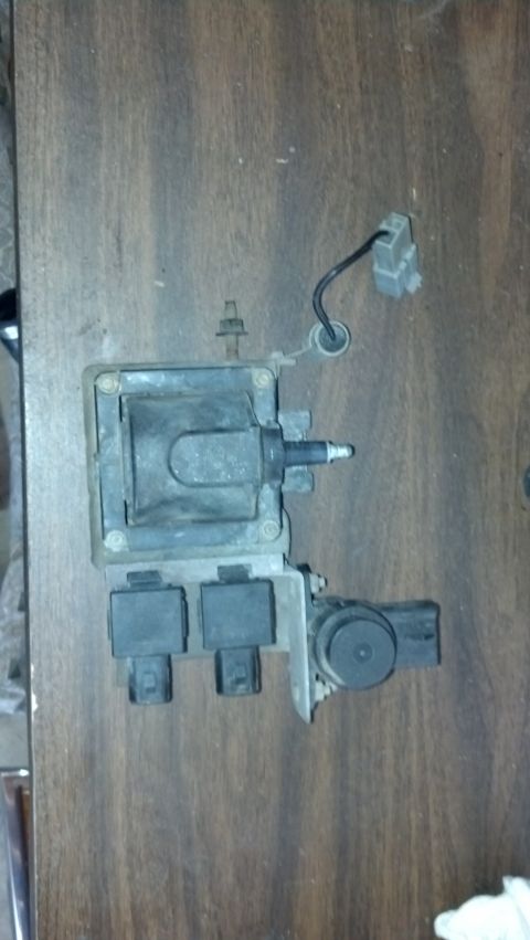 1993 Ford Bronco - Ignition coil pack removed from a vehicle, shown on a wooden table.