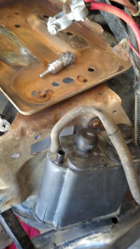 1993 Ford Bronco - Wire brush attachment sits on a rusty battery tray with electrical components visible.