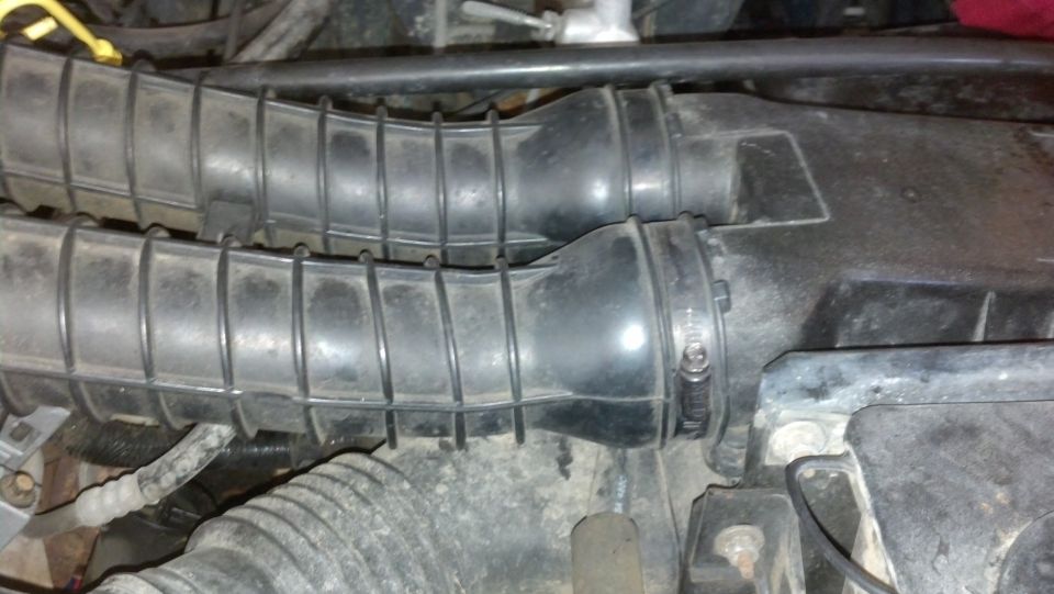Two black ribbed air intake hoses connected to a black box