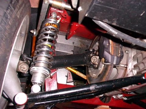 1967 Ford 427 - Close-up of a car's rear suspension and differential assembly, showing a coilover shock and brake caliper.