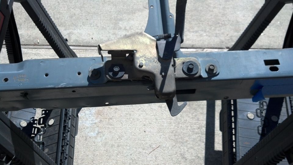 Close-up of a vehicle's frame section with a latch mechanism attached