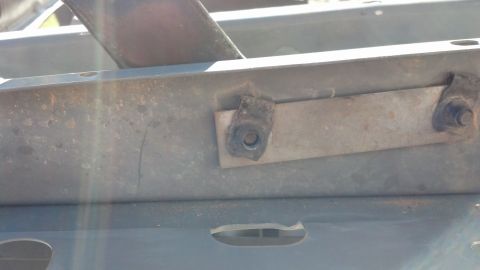 1993 Ford Bronco - Detail of a metal bracket and bolt, likely from a vehicle's frame or body.