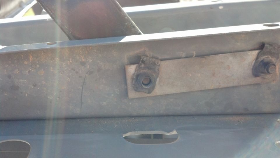 Close-up of a metal bracket with a bolt on a vehicle frame