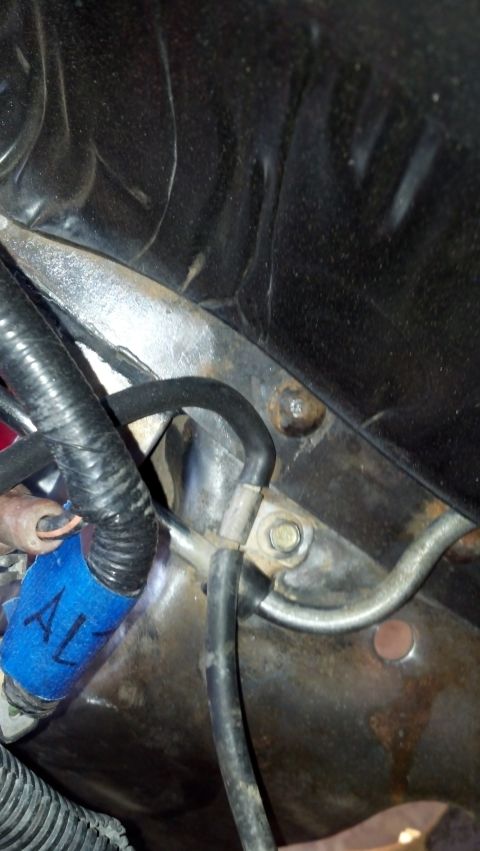 1993 Ford Bronco - Engine bay wiring and hoses with blue tape marking a component.