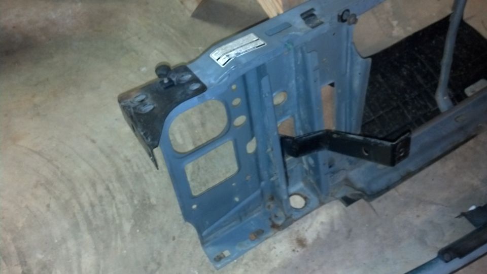 Blue metal frame piece with black bracket attached, on a concrete floor