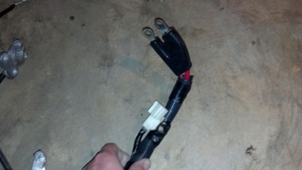 Automotive wiring harness with black protective wrapping and a white connector