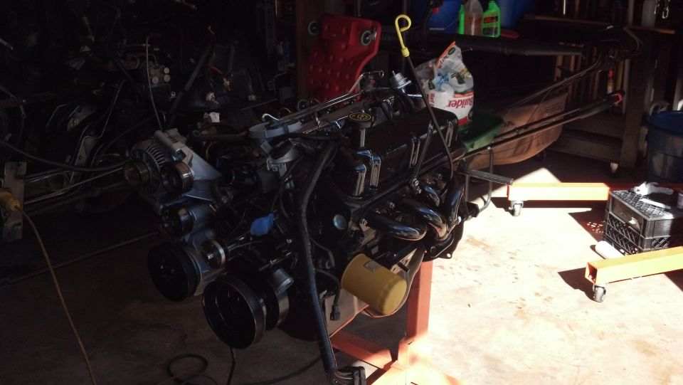 Ford V8 engine on an engine stand, with exhaust manifolds and oil filter visible