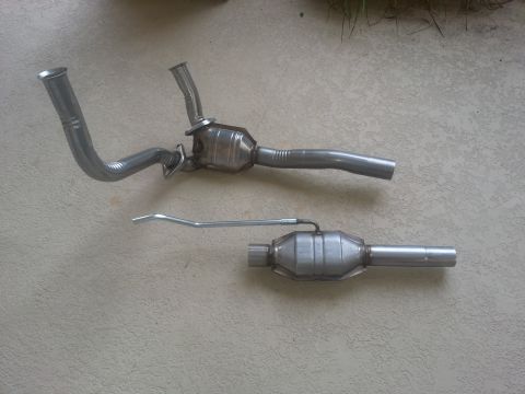 1994 Ford Bronco - Exhaust system components, likely for a vehicle, are shown on a textured surface.