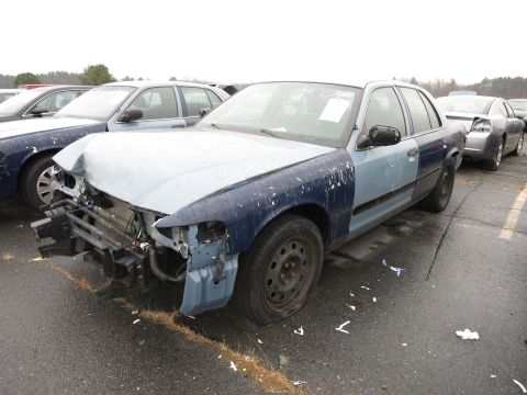 1991 Ford LTD Crown Victoria - Sedan with significant front-end damage and mismatched body panels sits in a lot.
