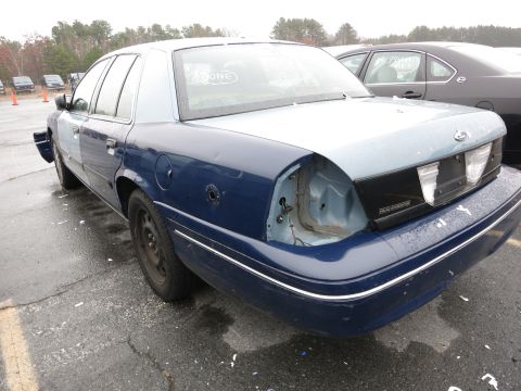 1991 Ford LTD Crown Victoria - Rear view of a damaged 1991 Ford Crown Victoria, showing missing taillights and body damage.