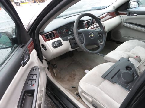 1991 Ford LTD Crown Victoria - The interior of a car shows tan seats and a dashboard with a Chevrolet emblem on the steering wheel.
