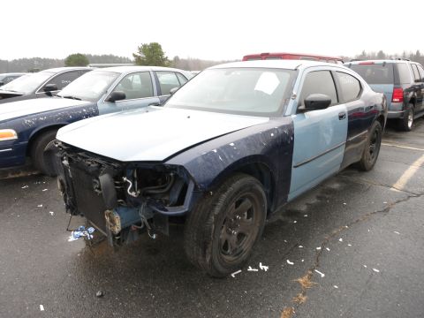 1991 Ford LTD Crown Victoria - A damaged two-tone blue sedan sits in a lot, its front end exposed, with other vehicles visible in the background.