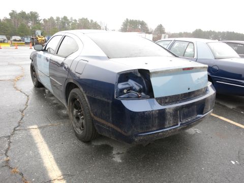 1991 Ford LTD Crown Victoria - A damaged blue sedan sits in a lot next to another vehicle, with one taillight missing and mismatched body panels.