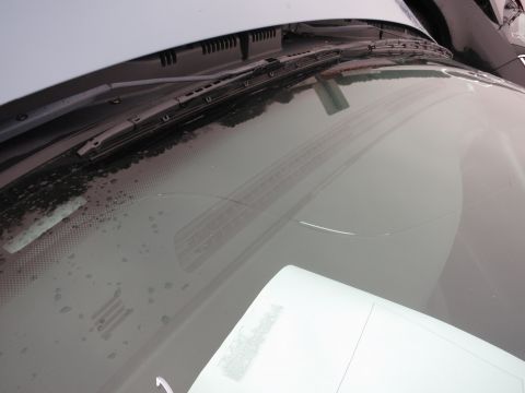 1991 Ford LTD Crown Victoria - Close-up view of a car's windshield wipers and the area below them.