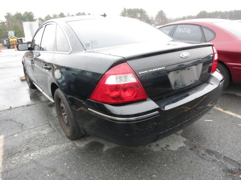 1991 Ford LTD Crown Victoria - Rear view of a black sedan with a 'FIVE HUNDRED' badge, parked outdoors.