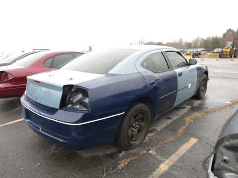 1991 Ford LTD Crown Victoria - Dodge Charger in a parking lot, showing mismatched paint and damage to the rear.