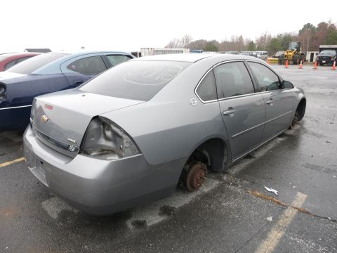1991 Ford LTD Crown Victoria - A gray sedan sits in a lot with its wheels removed, and a blue car is parked beside it.