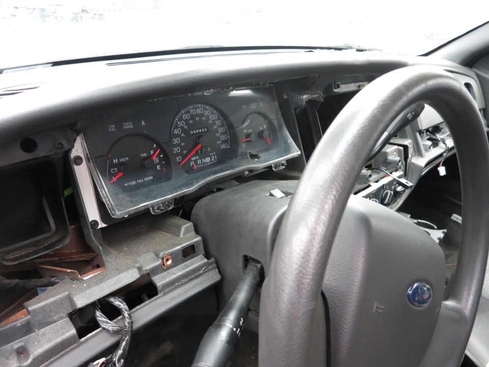 Dashboard of a 1991 Ford Crown Victoria LTD with the instrument cluster removed, showing wiring and steering column