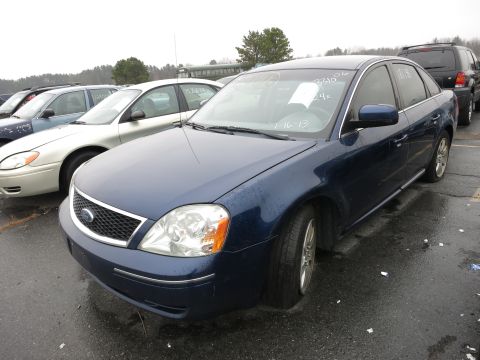 1991 Ford LTD Crown Victoria - Blue sedan with a flat front tire sits in a parking lot next to other vehicles.