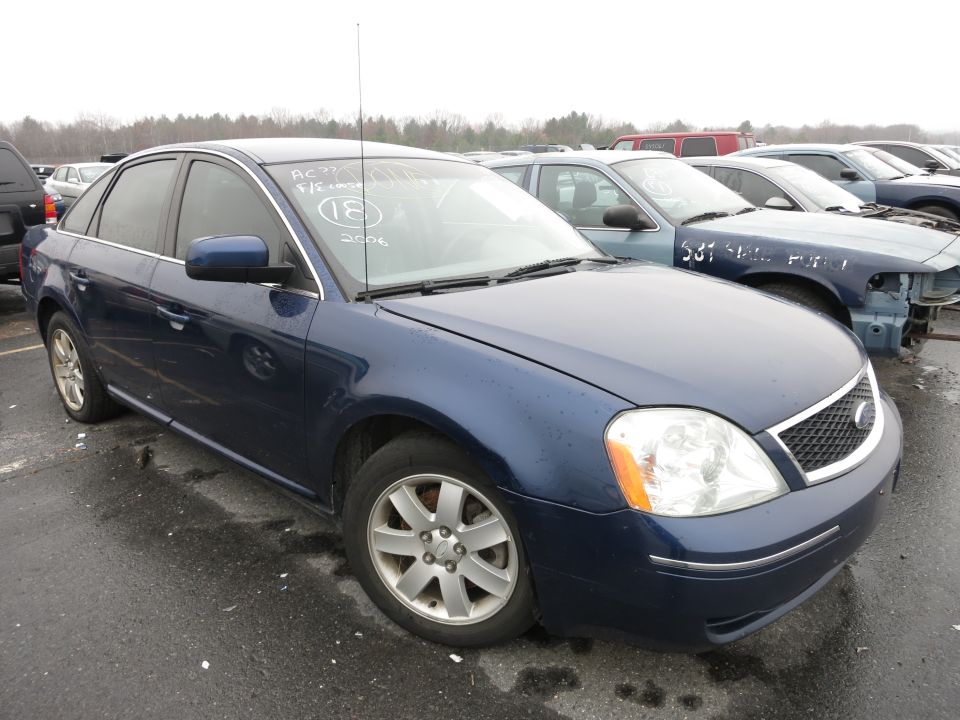 Blue sedan with a white sticker on the windshield. Other cars in a lot