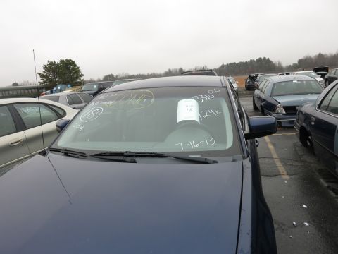 1991 Ford LTD Crown Victoria - A dark blue sedan is parked in a lot with other vehicles, its windshield marked with handwritten notes and a paper tag.