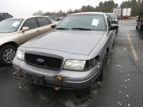 1991 Ford LTD Crown Victoria - A gray Ford Crown Victoria with a damaged front end is parked in a lot next to another car.