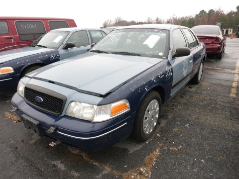 1991 Ford LTD Crown Victoria - A blue Ford Crown Victoria with a light blue hood and mismatched fenders sits in a lot next to another similar vehicle.