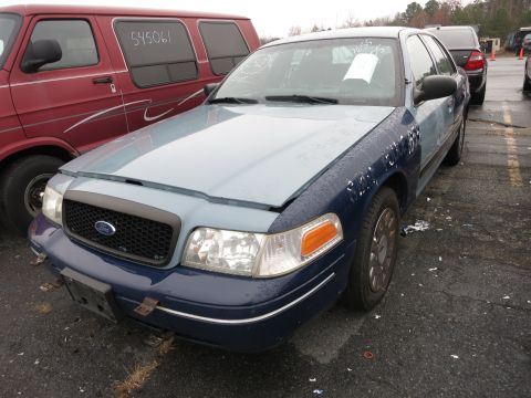 1991 Ford LTD Crown Victoria - Front view of a Ford Crown Victoria, showing its two-tone paint job and a red van in the background.