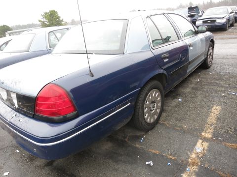 1991 Ford LTD Crown Victoria - A two-tone blue and silver sedan is parked in a lot with other vehicles visible.