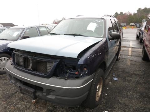 1991 Ford LTD Crown Victoria - Damaged SUV in a lot, missing front end parts. Paper on windshield has writing.