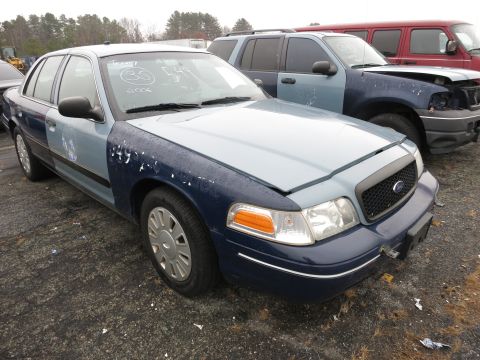 1991 Ford LTD Crown Victoria - This Ford Crown Victoria has a two-tone paint job and its hood is open, showing multiple vehicles in the background.