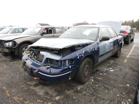 1991 Ford LTD Crown Victoria - This damaged 1991 Ford Crown Victoria LTD is in a junkyard with other cars.
