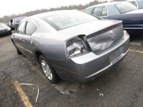 1991 Ford LTD Crown Victoria - Rear view of a damaged silver Dodge Charger, showing missing taillight and trunk damage.