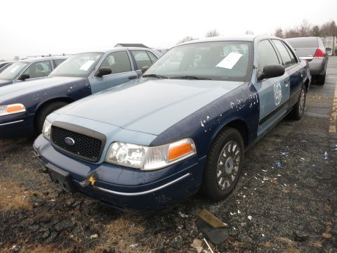 1991 Ford LTD Crown Victoria - A fleet of Ford Crown Victorias, possibly police vehicles, parked in a lot.