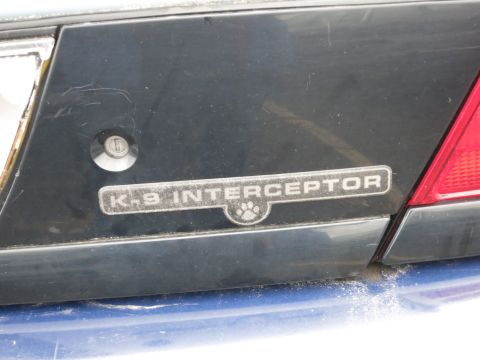 1991 Ford LTD Crown Victoria - The rear of a vehicle shows a 'K-9 INTERCEPTOR' badge with a paw print, indicating it was likely a police vehicle.