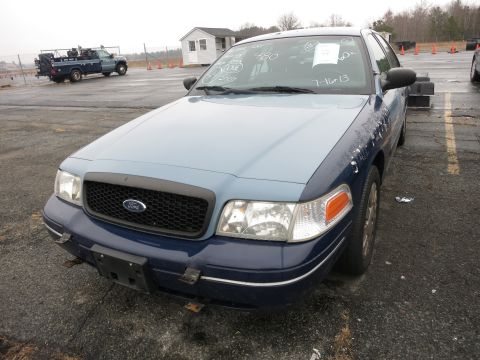 1991 Ford LTD Crown Victoria - A Ford Crown Victoria with a two-tone paint job sits in a parking lot, its windshield marked with writing.