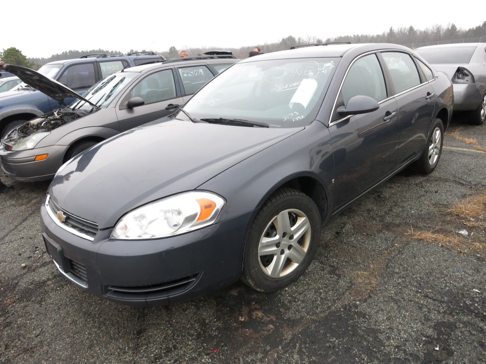 Dark gray sedan, 3/4 front view. Paper on windshield