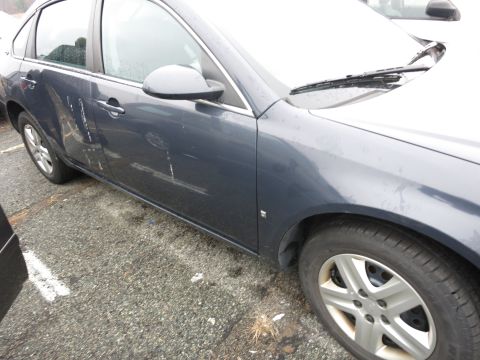 1991 Ford LTD Crown Victoria - Side view of a dark blue sedan showing damage to the driver's side door.