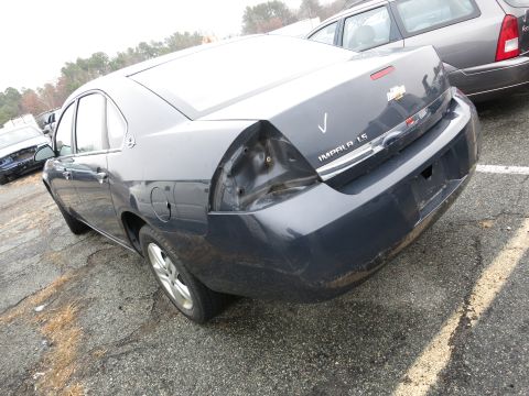 1991 Ford LTD Crown Victoria - A dark gray Chevrolet Impala LS sedan is parked in a lot with visible rear-end damage.
