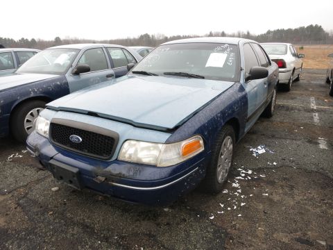 1991 Ford LTD Crown Victoria - A blue Ford Crown Victoria sits in a lot with its hood open, showing another vehicle behind it.