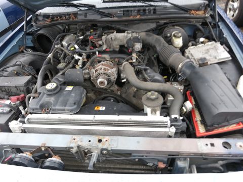1991 Ford LTD Crown Victoria - The engine bay of a 1991 Ford Crown Victoria LTD shows a V8 engine, radiator, and air filter assembly.