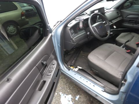 1991 Ford LTD Crown Victoria - Interior view of a blue car, with a second vehicle reflected in the driver's side window.
