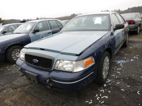 1991 Ford LTD Crown Victoria - This Ford Crown Victoria, likely from the early 2000s, is parked in a lot with other similar vehicles. The front bumper shows signs of dama…