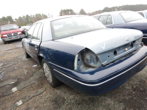 1991 Ford LTD Crown Victoria - Rear view of a blue and silver sedan, likely a 1991 Ford Crown Victoria LTD, with a missing taillight and bumper cover.